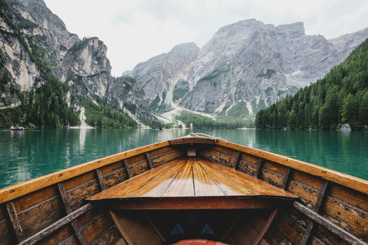 Stretched Canvas: brown wooden boat moving towards the mountain – Luca Bravo (Unsplash)