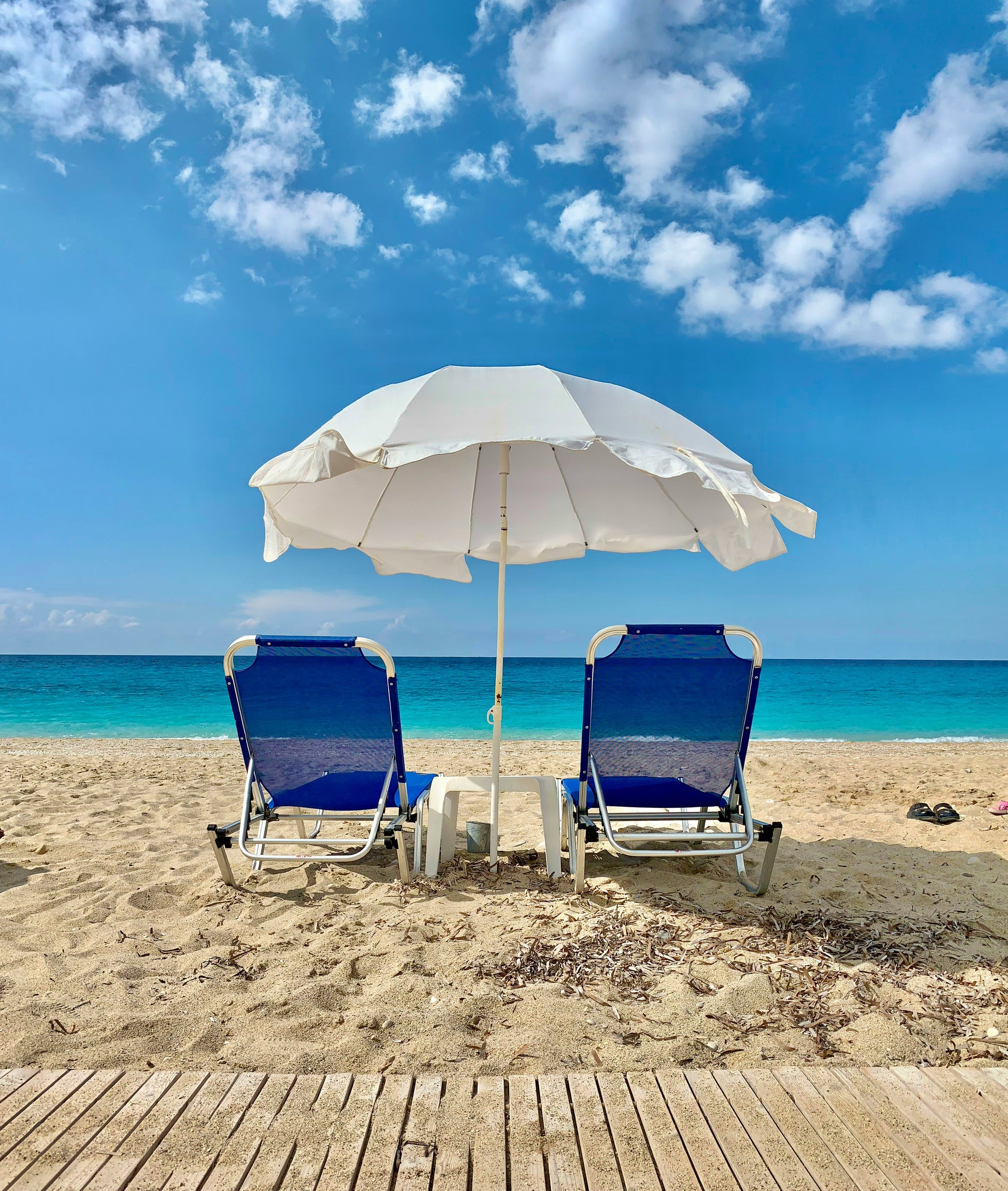 Stretched Canvas: blue and white chair under white umbrella on beach during daytime – Marko Kelecevic (Unsplash)