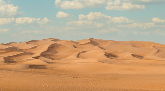 Poster: a large group of sand dunes under a blue sky – Haris khan (Unsplash)