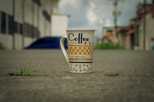 Poster: a coffee cup on a sidewalk – Arthur A (Unsplash)
